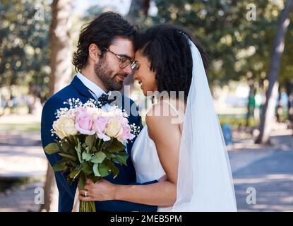 Coppia sposata, fiore bokeh e sorriso per matrimonio, matrimonio o amore impegno insieme nel parco. Sposo felice e sposa sorridente nella felicità per Foto Stock