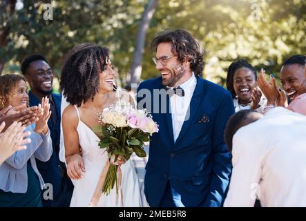 Festeggiamenti, applausi e sposi con ospiti felici, entusiasti e allegri. Amore interrazziale e felicità di coppia in occasione di matrimonio evento Foto Stock