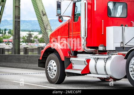 Day Cab di grado industriale trattore industriale americano, potente e classico, con carro di perforazione rosso grande, che trasporta carichi commerciali in marcia sulla trave interstatale Columb Foto Stock