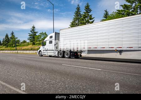 Cabina alta per impieghi industriali potente semirimorchio grande carro di trasporto lungo classico bianco per trasporto di carichi commerciali nella corsa di un semirimorchio frigorifero Foto Stock