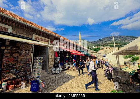 Mostar, Bosnia-Erzegovina - 12 maggio 2022: Città vecchia nel centro della città di Mostar con il colorato souvenir tradizionale con turisti a piedi Foto Stock