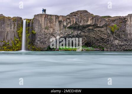 Fossholl, Islanda - 25 luglio 2022: I turisti si trovano vicino a una piccola cascata accanto a Godafoss Foto Stock