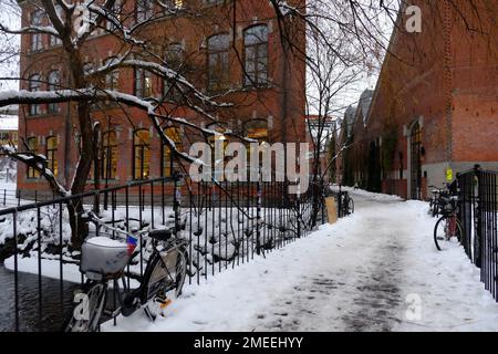 Le biciclette sul ponte coperto di neve con edifici sullo sfondo in una fredda giornata invernale Foto Stock