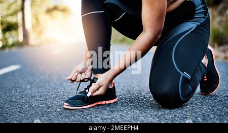 Preparati a gestire la tua vita. una donna irriconoscibile che legava le scarpe. Foto Stock