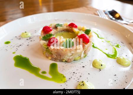 L'insalata di vari ingredienti è ben organizzata a forma di anello su un piatto bianco. Foto Stock
