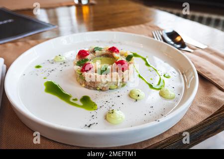 L'insalata di vari ingredienti è ben organizzata a forma di anello su un piatto bianco. Foto Stock