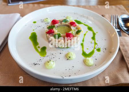 L'insalata di vari ingredienti è ben organizzata a forma di anello su un piatto bianco. Foto Stock