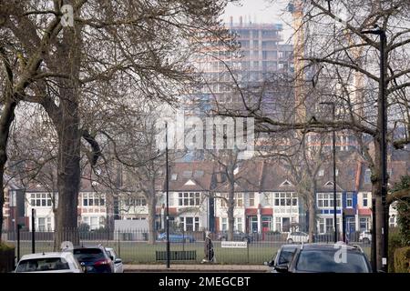 Una vista panoramica delle case residenziali londinesi in primo piano e dei nuovi alti edifici in costruzione nella capitale - e in lontananza, il crescente sviluppo a nove Elms a Battersea, visto da Ruskin Park, uno spazio verde a sud di Londra a Lambeth, il 23rd gennaio 2023, a Londra, Inghilterra. Foto Stock