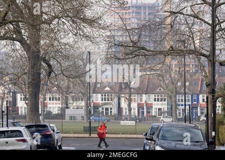 Un postino della Royal Mail consegna gli invii postali su Ferndene Road dove un nuovo alto sviluppo nel cantiere di Higgs è visto in costruzione a Loughborough Junction a Lambeth, il 23rd gennaio 2023, a Londra, Inghilterra. Foto Stock