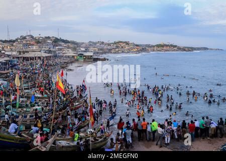 Costa del Capo, Ghana - 05 aprile 2022: Costa dell'Oceano Atlantico con le barche e la gente africana locale del Ghana Foto Stock