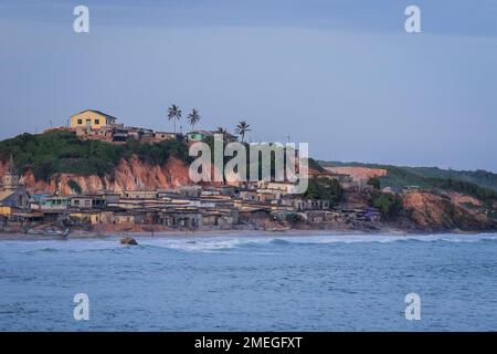 Costa del Capo, Ghana - 05 aprile 2022: Costa dell'Oceano Atlantico con le barche e la gente africana locale del Ghana Foto Stock