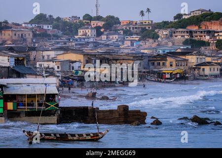 Costa del Capo, Ghana - 05 aprile 2022: Costa dell'Oceano Atlantico con le barche e la gente africana locale del Ghana Foto Stock