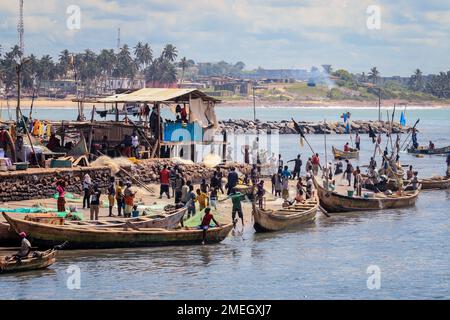 Vista sull'Oceano Atlantico nel porto di Elmina con i pescatori sulle barche in Ghana, Africa occidentale Foto Stock