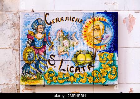 Piastrelle colorate in ceramica su un muro di casa, caratteristica di questa forma d'arte nella città di Sciacca. Foto Stock