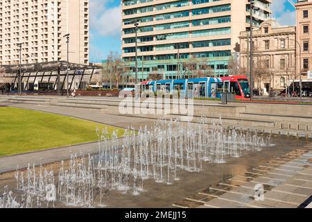 Adelaide City, South Australia - 19 agosto 2019: Victoria Square fontana in una giornata intensa con il tram della metropolitana di Adelaide che passa sullo sfondo Foto Stock