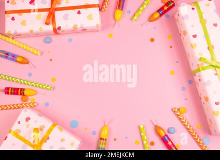 composizione circolare per le vacanze di candele, scatole da regalo e confetti su sfondo rosa, concetto di compleanno di ragazza o donna. Foto Stock