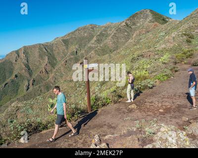 Buenavista del Norte, Tenerife, Isole Canarie, Spagna, dicembre 22, 2021: Escursionisti e turisti al cartello a sentiero nel Parco rurale de Teno Foto Stock