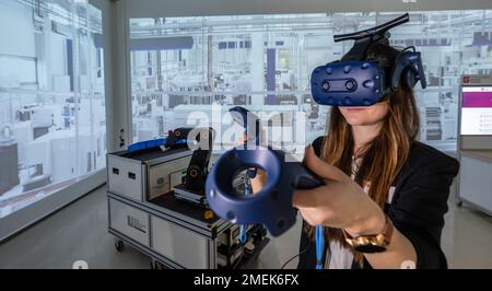 24 gennaio 2023, Sassonia, Chemnitz: Luise Weißflog del Centro digitale PMI dell'Università di tecnologia di Chemnitz dimostra l'uso della tecnologia VR nella pianificazione di fabbrica presso la fabbrica sperimentale e digitale dell'università. La fabbrica di modelli e apprendimento dell'università si occupa della ricerca, dello sviluppo e della qualificazione di concetti e tecnologie innovative della digitalizzazione. L'obiettivo è quello di testare nuovi concetti e tecnologie in un ambiente di produzione orientato all'industria e di promuoverne il trasferimento nella pratica. Al suo incontro fuori città a Chemnitz, il gabinetto sassone è dealin Foto Stock