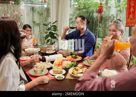 Grande famiglia che mangia la cena insieme godendosi la celebrazione cinese di Capodanno Foto Stock
