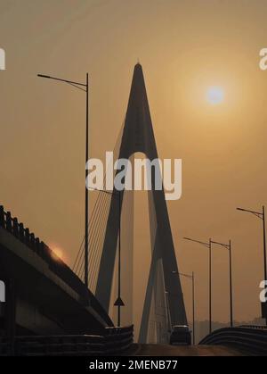 Un'auto sta guidando sul viadotto verso la direzione del sole che tramonta. Chongqing, Cina. Foto Stock