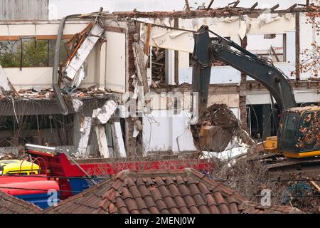 Demolizione di una vecchia casa con un escavatore. Foto Stock