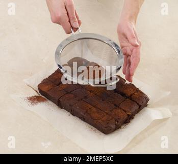 Brownie al cioccolato e alla nocciola, spolverate con polvere di cioccolato Foto Stock