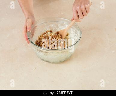 Preparazione di biscotti Stilton e Noce, mescolando nel muts Foto Stock