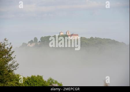 Francia, Borgogna, Yonne, Vezelay, Basilique Sainte-Marie-Madeleine, cattedrale in collina, nebbia sui campi Foto Stock