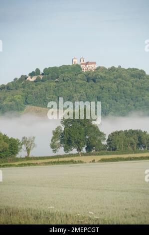 Francia, Borgogna, Yonne, Vezelay, Basilique Sainte-Marie-Madeleine, cattedrale in collina, nebbia sui campi Foto Stock