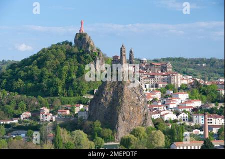 Francia, Auvergne, alta Loira, Aiguilhe vicino a le Puy-en-Velay, Saint Michel d'Aiguilhe cappella costruita su ripida collina di roccia vulcanica, collina Rocher Corneille con la statua della Vergine Maria sullo sfondo Foto Stock