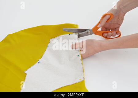 Taglio del tessuto intorno al motivo del dresssaker, primo piano Foto Stock