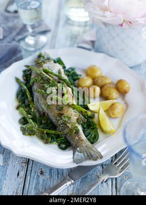 Sauted trout on appassì spinaci bolliti con patate baby Foto Stock