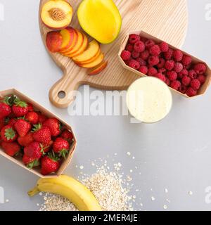Ingredienti Smoothie, fragole, lamponi e pesche tagliate a fette, mango e banana Foto Stock