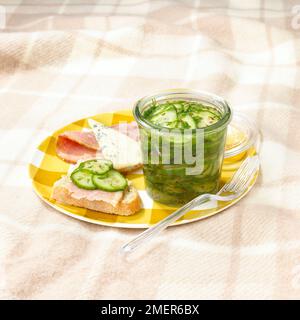 Prosciutto e pane affettato e vasetto di cetriolo e sottaceti all'aneto Foto Stock