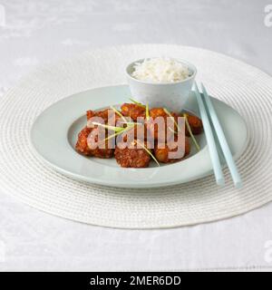 Generale del Tso pollo serviti su letto di riso, bacchette Foto Stock