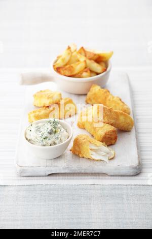 Polenta coperto dita di pesce, patatine fritte e salsa tartaro Foto Stock