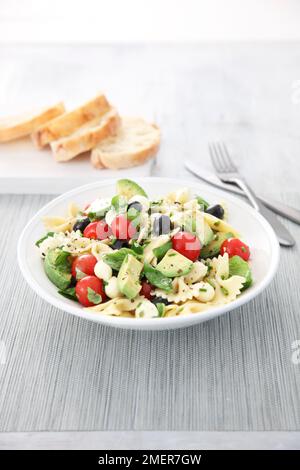 Ciotola di farfalle, olive, avocado e pomodoro Foto Stock