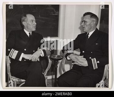 Coast Guardsman riferisce che il Sub affonda al Comandante. Il vice ammiraglio Russell R. Waesche, U. S. Coast Guard Commandant, a sinistra, ottiene un conto di prima mano da Lieut. Il comandante Maurice D. Jester di come il tagliatore della Guardia Costiera degli Stati Uniti Icarus, sotto il suo comando, fece esplodere una U-boat nazista in superficie, la ingaggiò con cannoni da ponte e prese 33 prigionieri. Lieut. Il comandante Jester, ora di stanza a Miami, in Florida, ha ricevuto la Navy Cross per l'exploit. Foto Stock