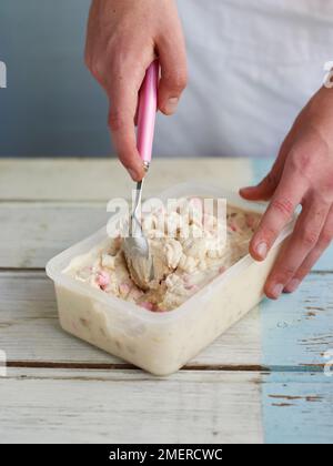 Miscela di yogurt congelato in una vasca di plastica Foto Stock