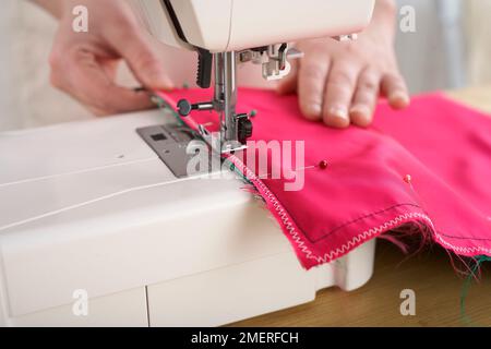 Rotolo di manicure in seta tailandese, utilizzando l'impostazione a zig-zag, cucire a macchina intorno al tessuto di rivestimento Foto Stock