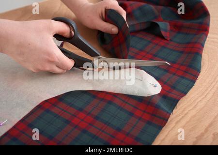 Creazione di una giacca per cani, utilizzando una dima, puntina sul materiale e ritagliare Foto Stock