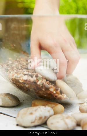 Tavolo giardino d'acqua, posizionamento pietre su ghiaia Foto Stock