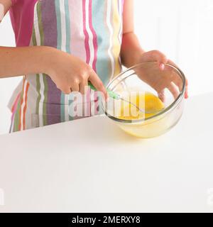 Sbattere le uova in una ciotola, 8 anni Foto Stock