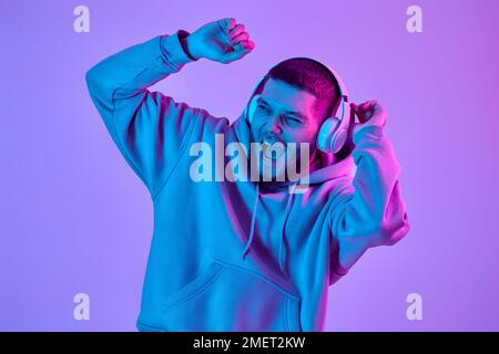 uomo con cuffie in felpa che ascolta la musica preferita Foto Stock