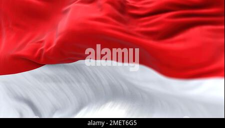 La bandiera nazionale indonesiana sventola nel vento. La Repubblica di Indonesia è uno Stato del Sud-est asiatico. Tessuto ondulato. Sfondo strutturato. Realistico Foto Stock