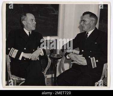 Coast Guardsman riferisce che il sub affonda al comandante. Il vice ammiraglio Russell R. Waesche, comandante della Guardia Costiera degli Stati Uniti, a sinistra, ottiene un conto di prima mano da Lieut. Il comandante Maurice D. Jester di come il tagliatore della Guardia Costiera degli Stati Uniti Icarus, sotto il suo comando, fece esplodere una U-boat nazista in superficie, la ingaggiò con cannoni da ponte e prese 33 prigionieri. Lieut. Il comandante Jester, ora di stanza a Miami, in Florida, ha ricevuto la Navy Cross per l'exploit. Foto Stock