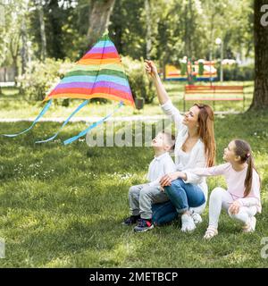 madre bambini che giocano con aquilone Foto Stock