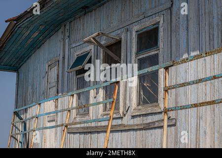 La finestra della vecchia casa in legno di legno sullo sfondo di pareti in legno. Foto Stock