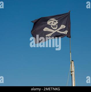 jolly roger. Pirata flag.contro lo sfondo del cielo blu. Foto Stock