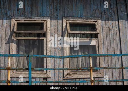 La finestra della vecchia casa in legno di legno sullo sfondo di pareti in legno. Foto Stock